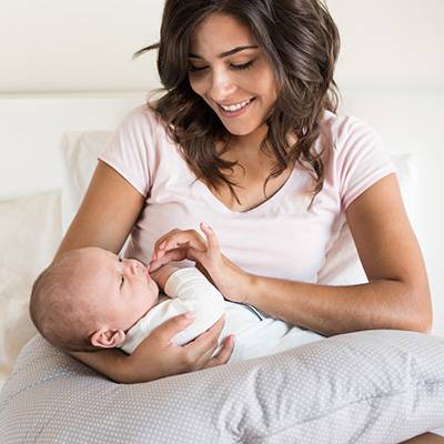young mother holds baby in bed